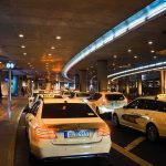 Des voitures-taxis attendent sous un hall souterrain éclairé