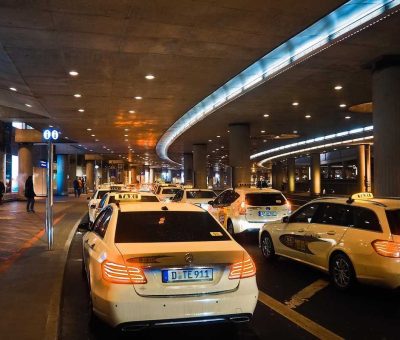 Des voitures-taxis attendent sous un hall souterrain éclairé