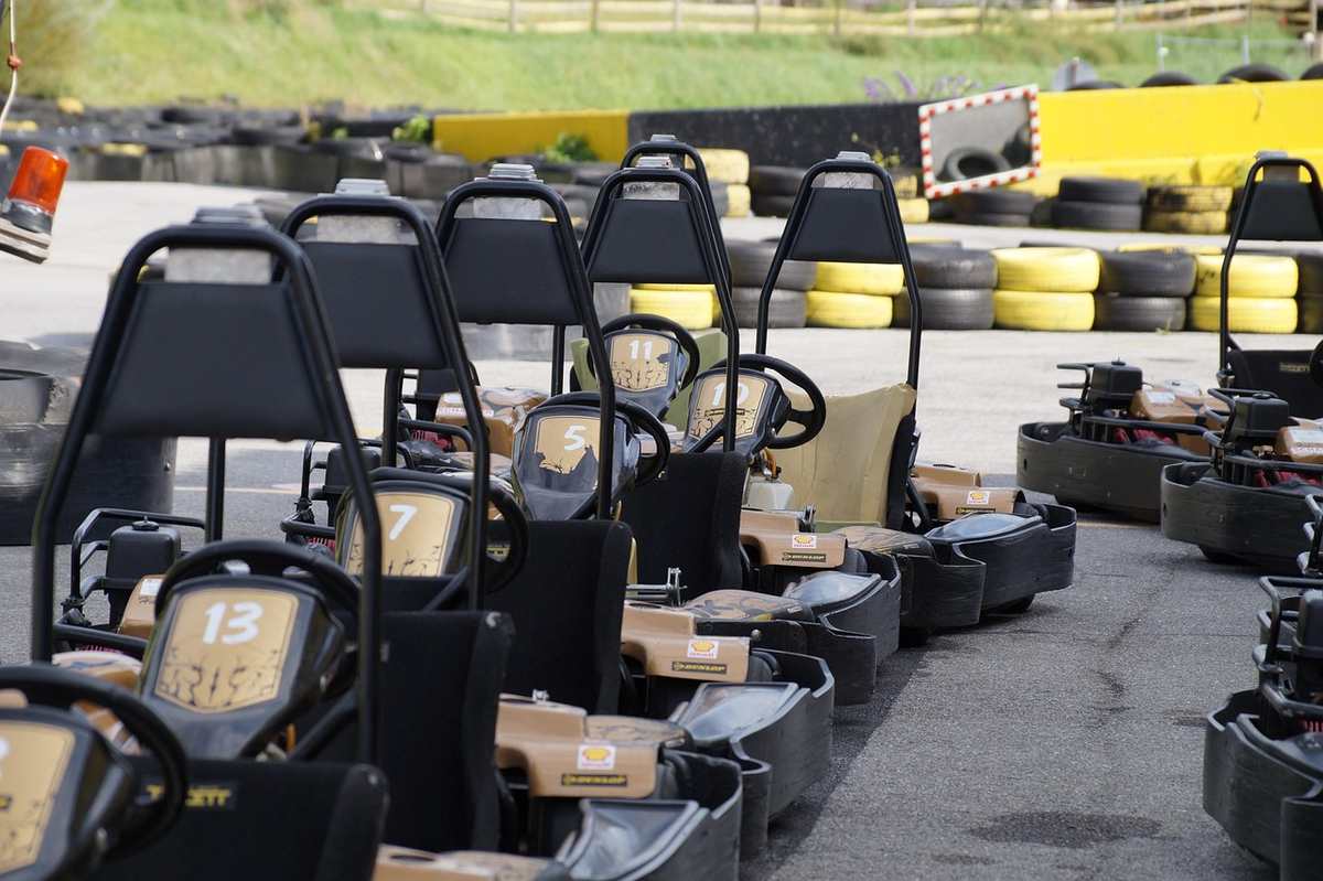 Des kartings alignés sur un circuit, prêts à être pilotés