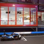 Un kart sur piste intérieure devant une salle vitrée