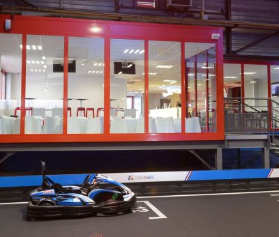 Un kart sur piste intérieure devant une salle vitrée