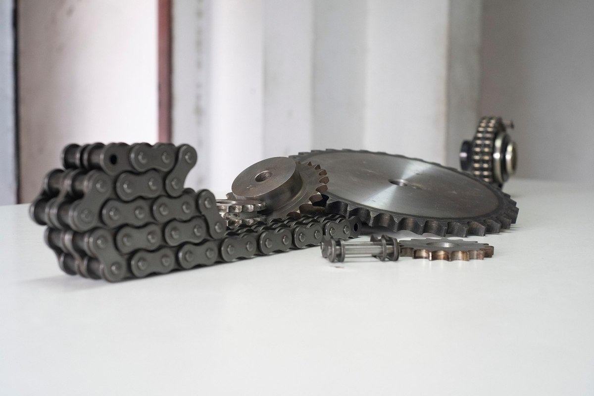 Chaîne et roues dentées sur une table blanche Chaîne et roues dentées sur une table blanche
